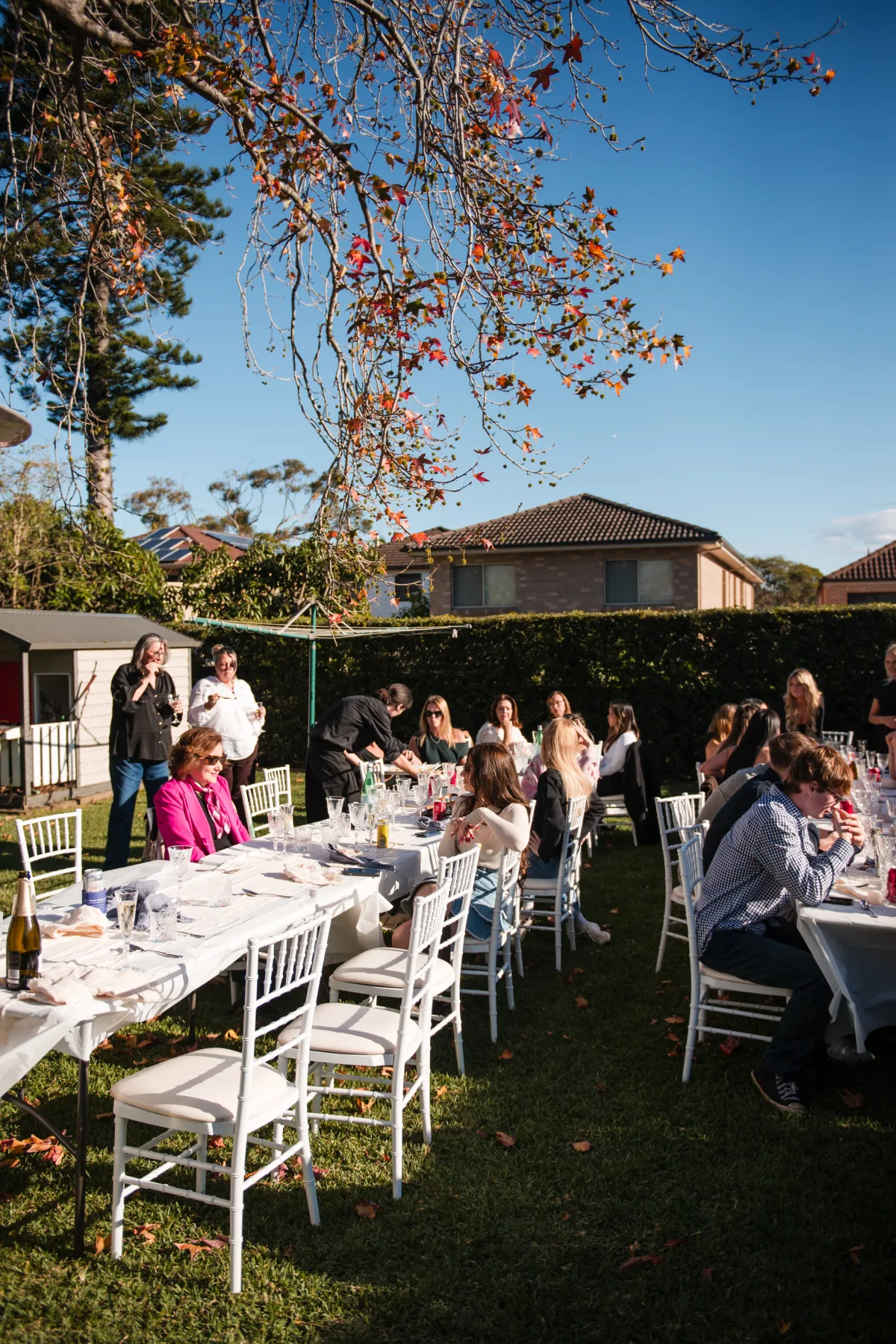 Guests seated at a long backyard birthday lunch