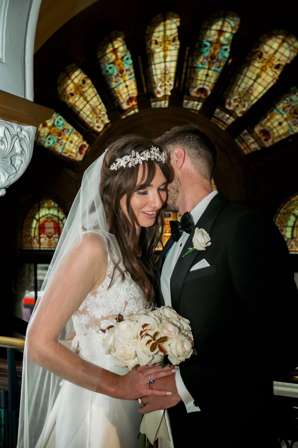 Wedding party laughing together at arched window, Sydney CBD